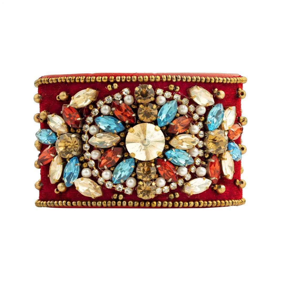 Decorative clutch with colorful gemstones and pearls on a red background