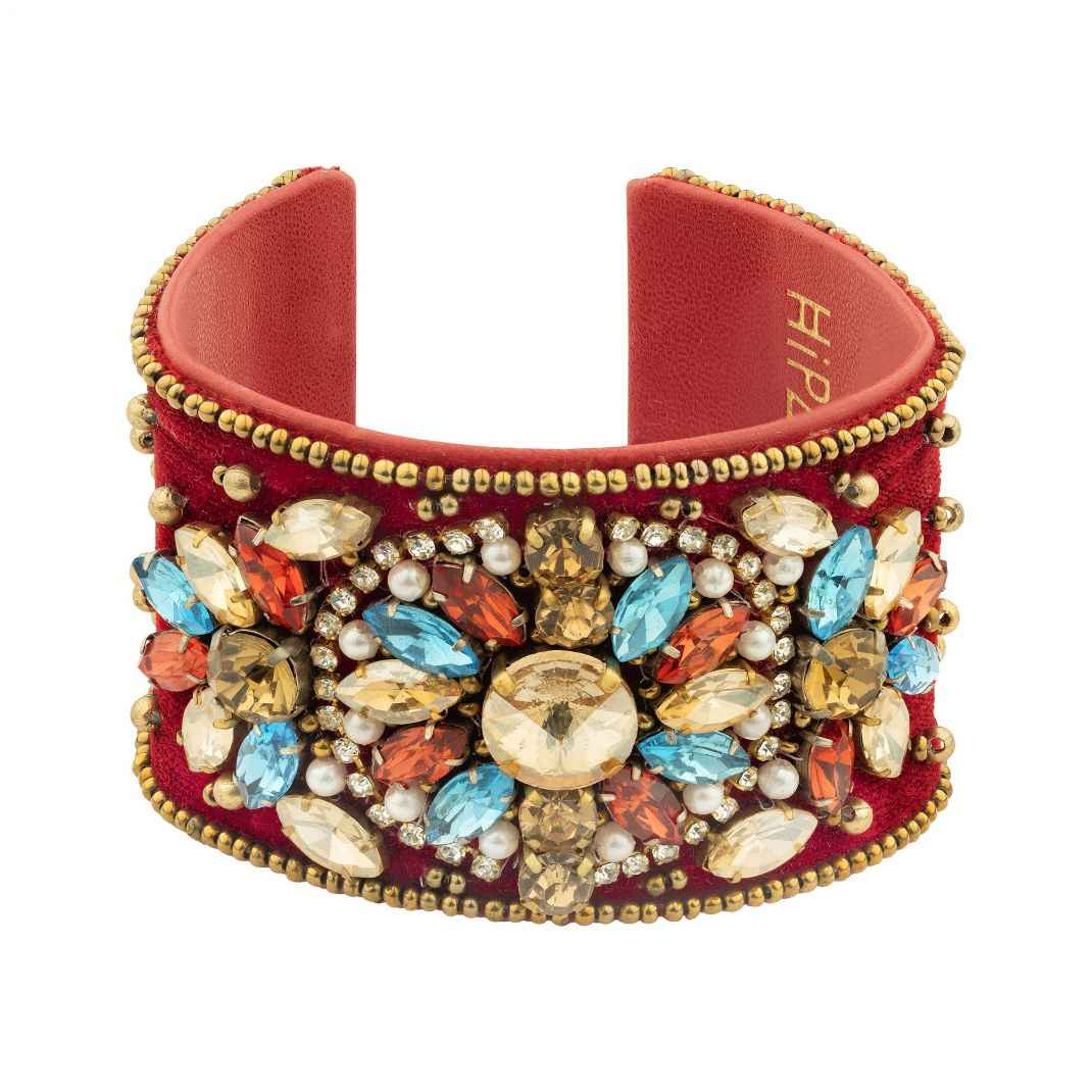 Red bracelet with colorful gemstones and gold accents on a white background
