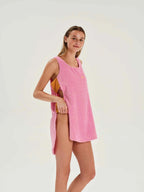 Woman wearing a pink sleeveless dress on a white background
