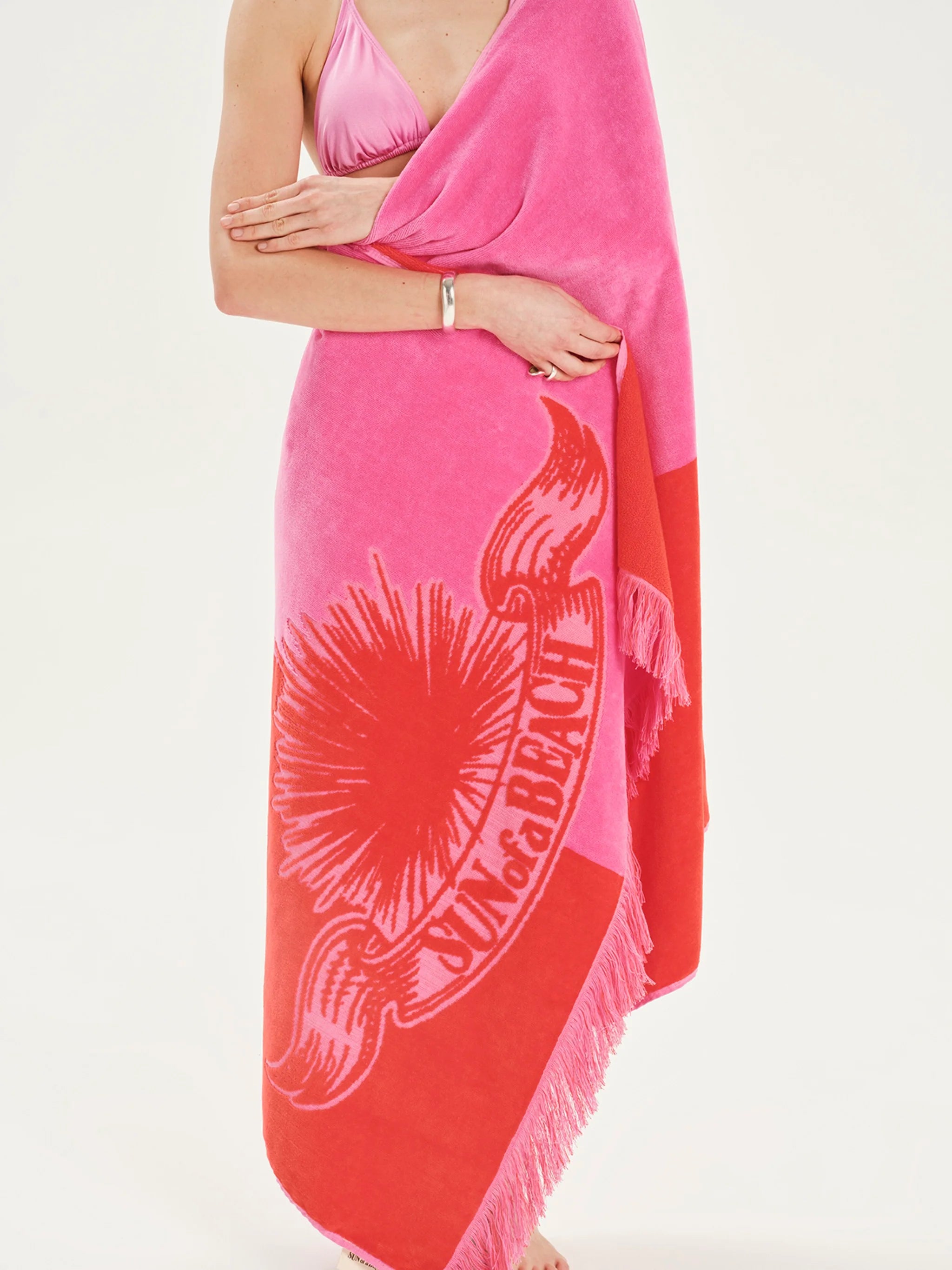 Pink and red beach towel with a design on a white background
