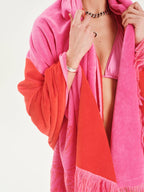 Person wearing a pink and red robe with a white background
