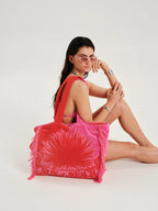 Woman holding a pink tie-dye bag on a white background