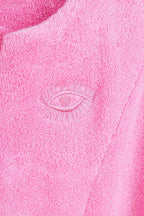 Close-up of pink fabric with an embroidered eye design