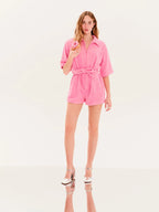 Woman wearing a pink romper on a white background
