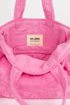 Pink textured bag with a visible brand label on a light background