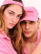 Two people wearing pink caps and robes, with a clear background