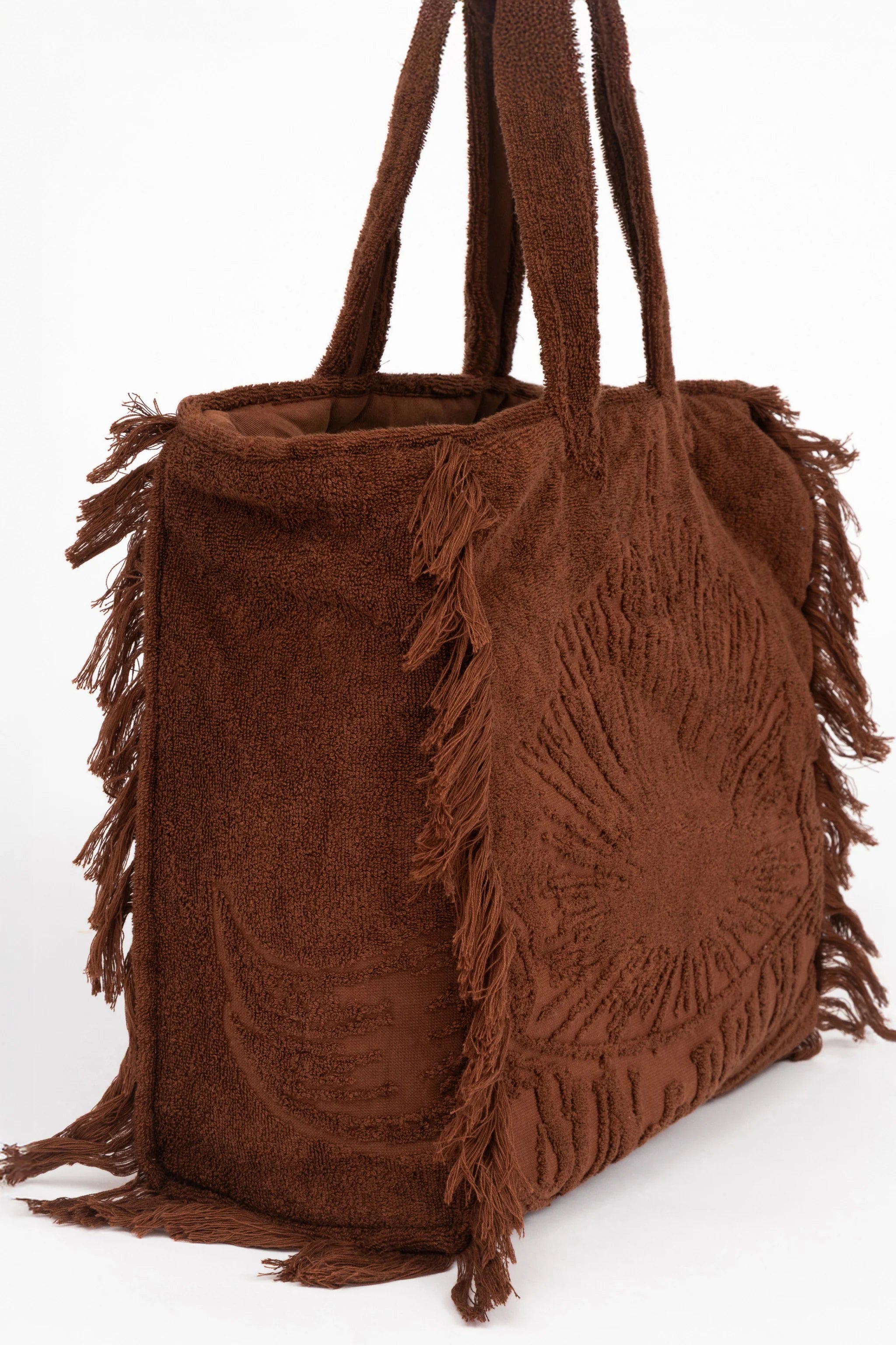 Brown suede handbag with fringe details on a white background