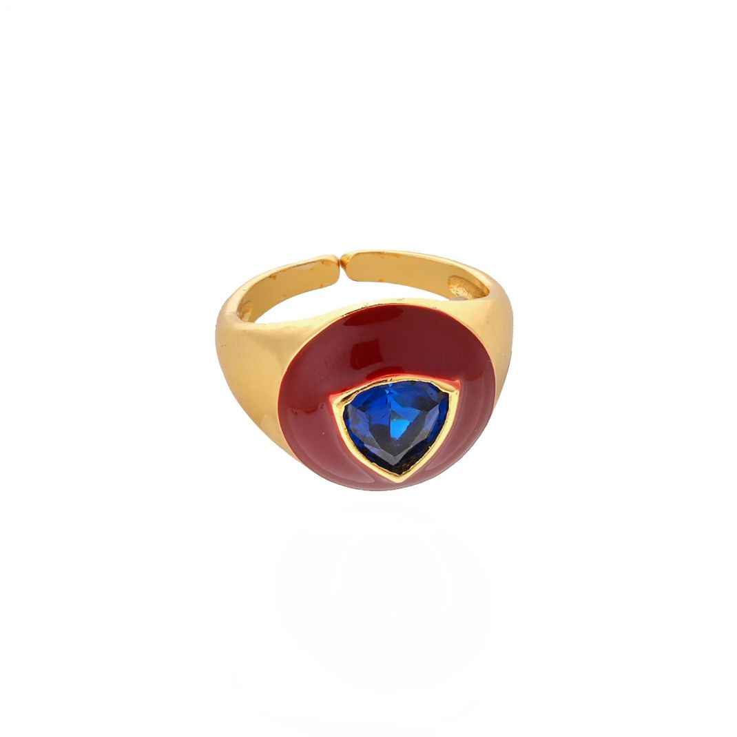 Gold ring with a red stone and blue gem on a white background