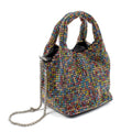 A small structured handbag covered in dense multicolored rhinestones, with two top handles, a silver chain strap, and black interior lining, photographed on a clean white background.