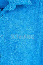 Close-up of a blue textured fabric with a brand logo.