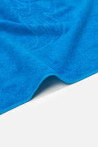 Close-up of a blue towel with a textured pattern on a white background