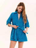Woman wearing a blue robe against a white background