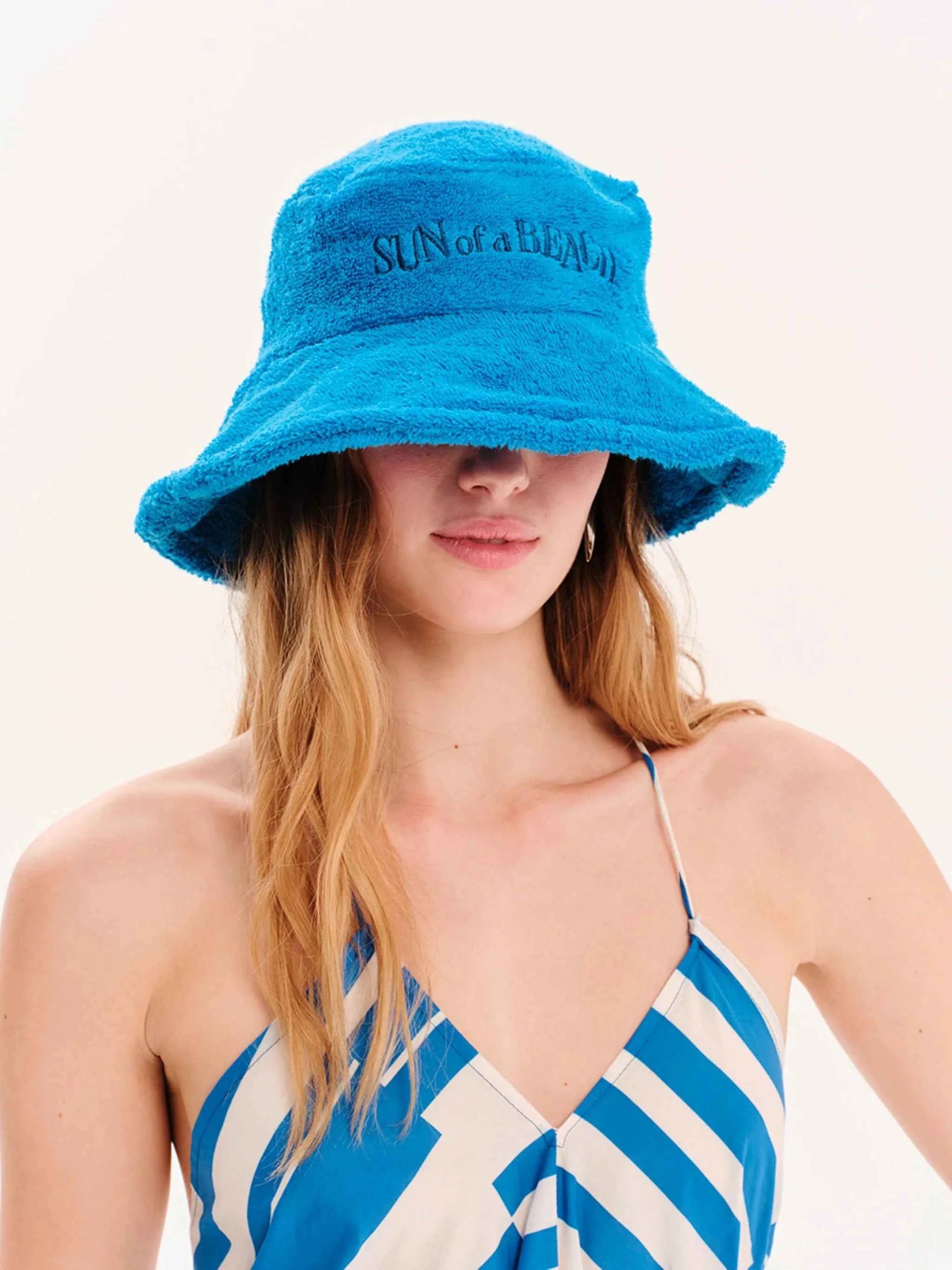 Woman wearing a blue bucket hat with text on a white background