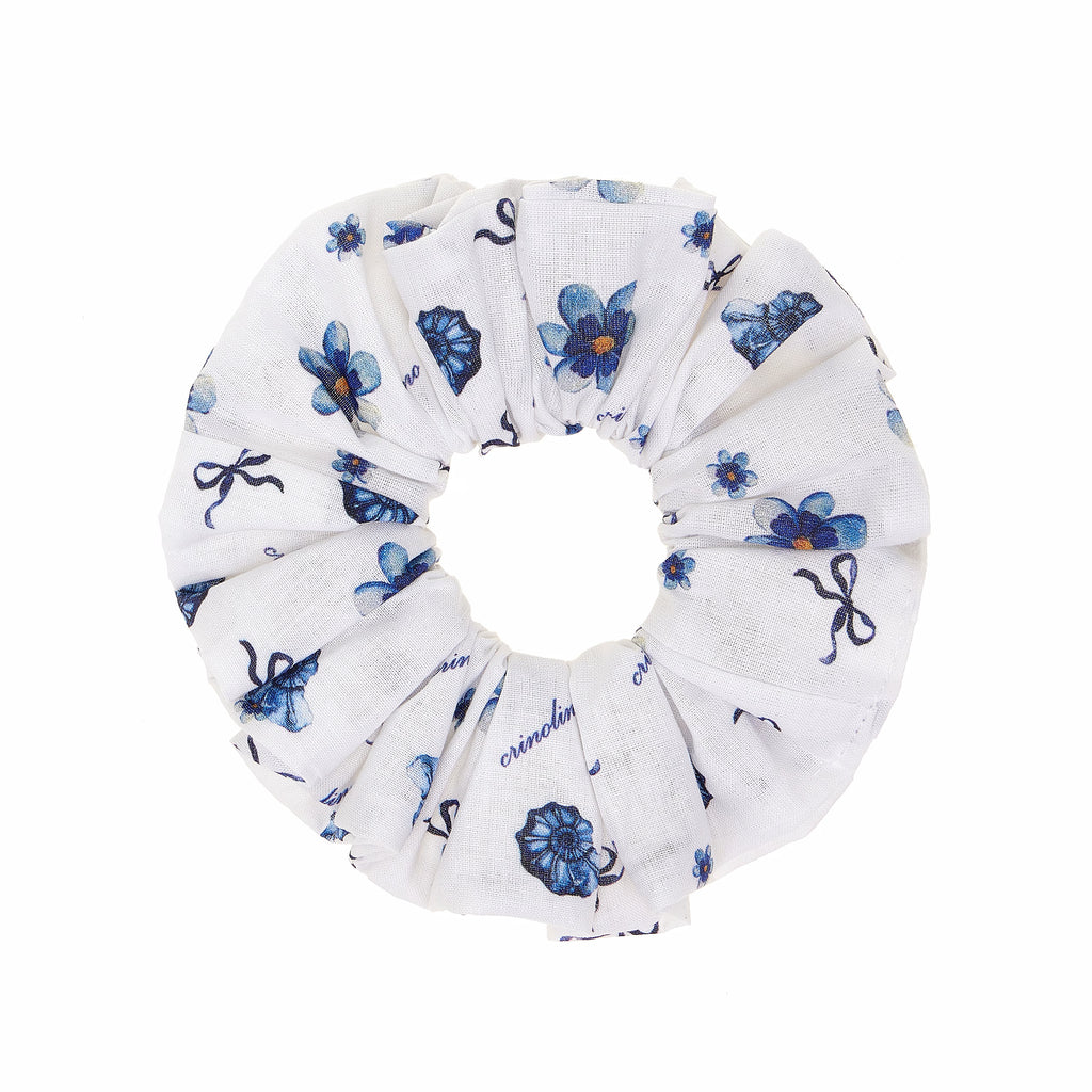 White scrunchie with blue floral and bow pattern on a white background