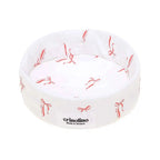 White pet bed with red bow pattern and 'crinolino' branding on a white background