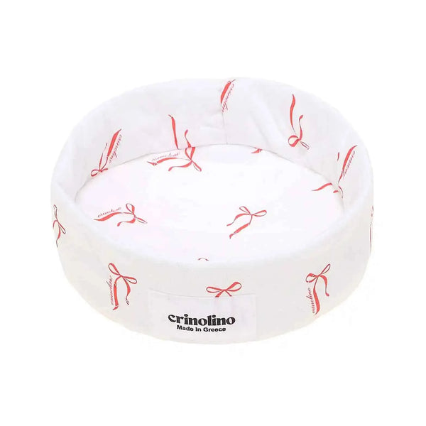 White pet bed with red bow pattern and 'crinolino' branding on a white background