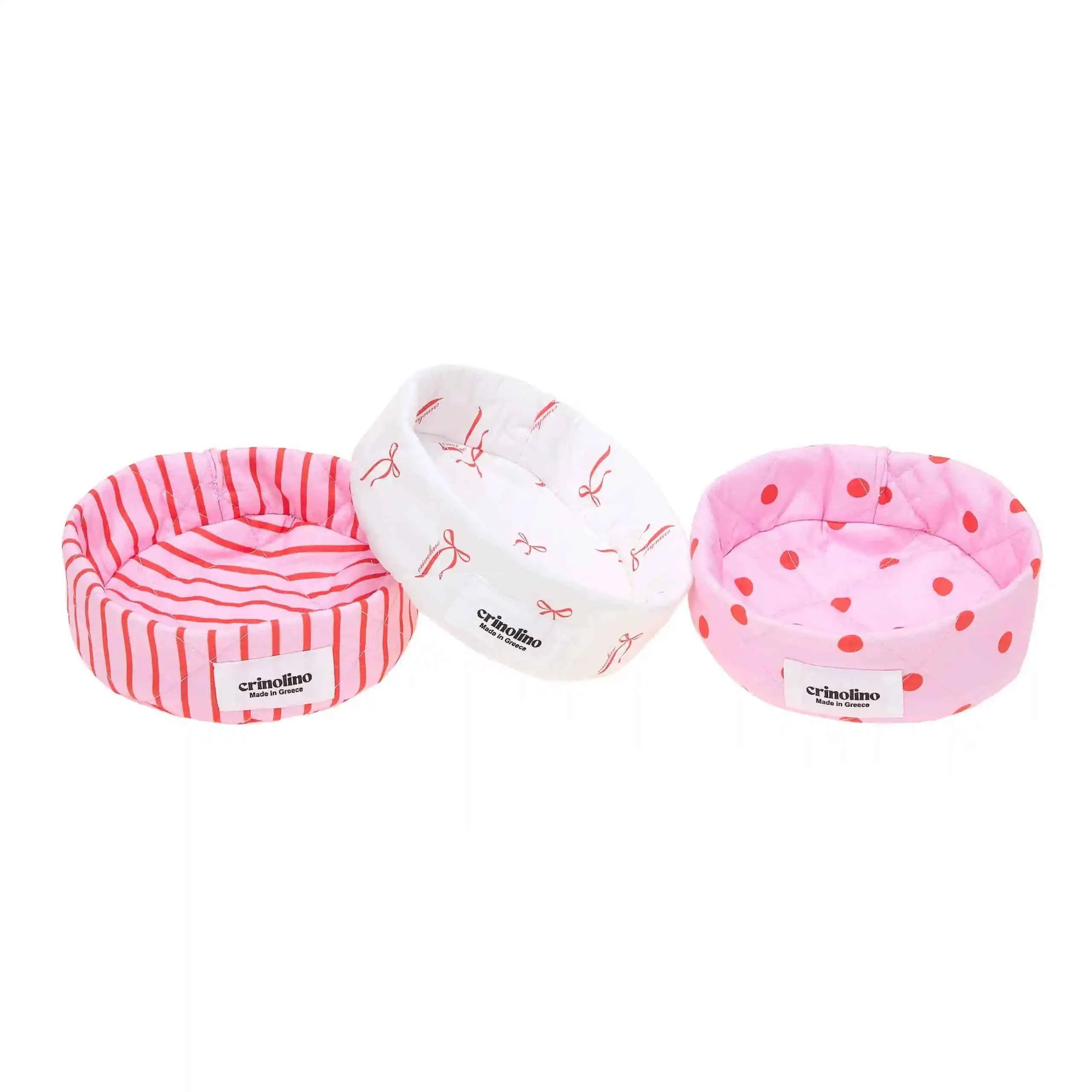 Three pink pet beds with different patterns on a white background