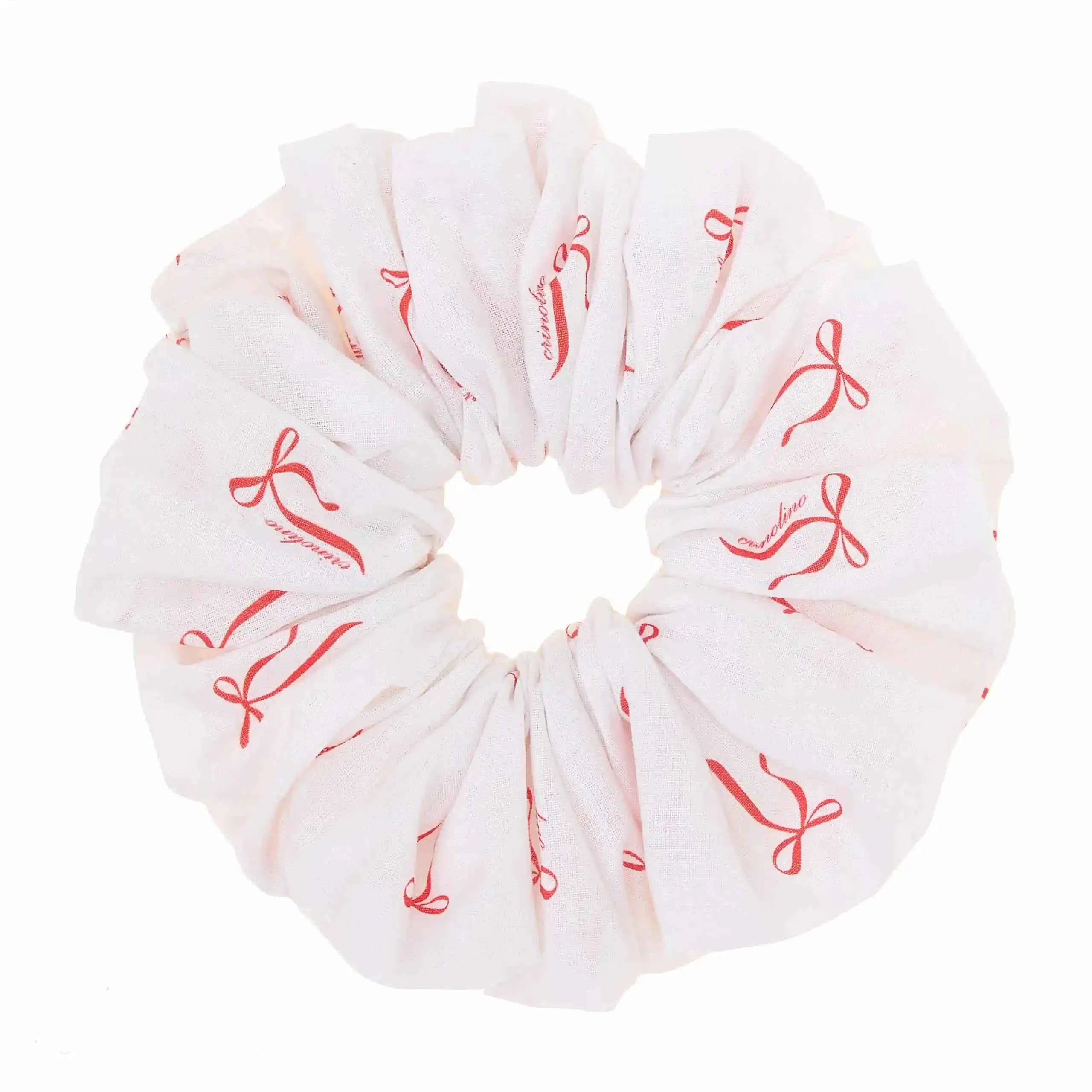 White scrunchie with red bow pattern on a white background