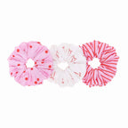Three colorful scrunchies on a white background