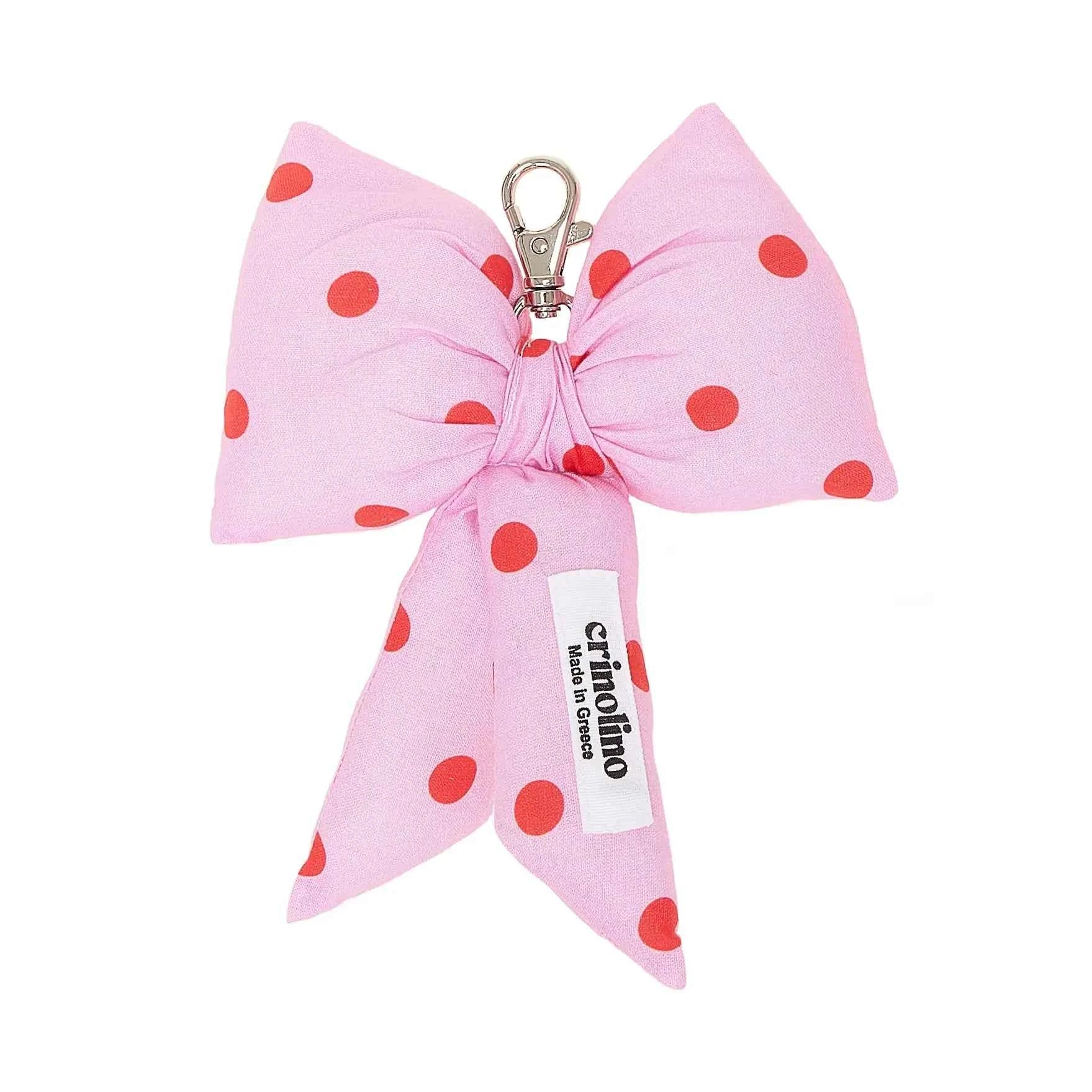 Pink polka dot bow keychain with a visible brand label on a white background