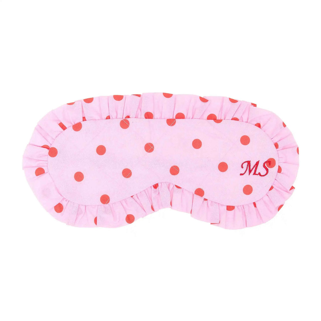 Pink eye mask with red polka dots and initials 'MS' on a white background