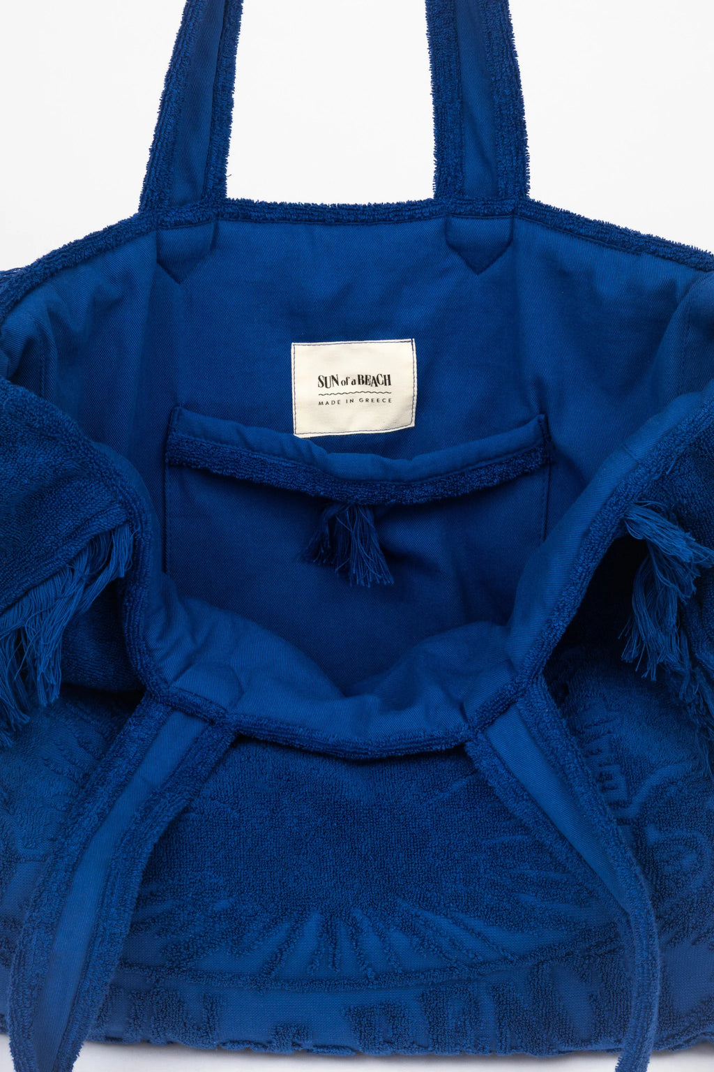 Blue bag with fringes and a visible brand label on a white background