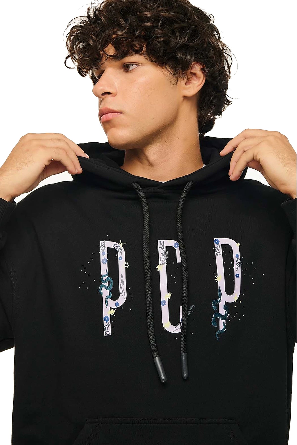 A man wearing a black pullover hoodie with a large white 'PCP' graphic across the chest, featuring blue and yellow paint-splatter details, set against a plain white background.