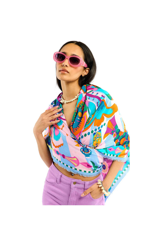 Woman wearing a colorful patterned shirt and sunglasses on a white background