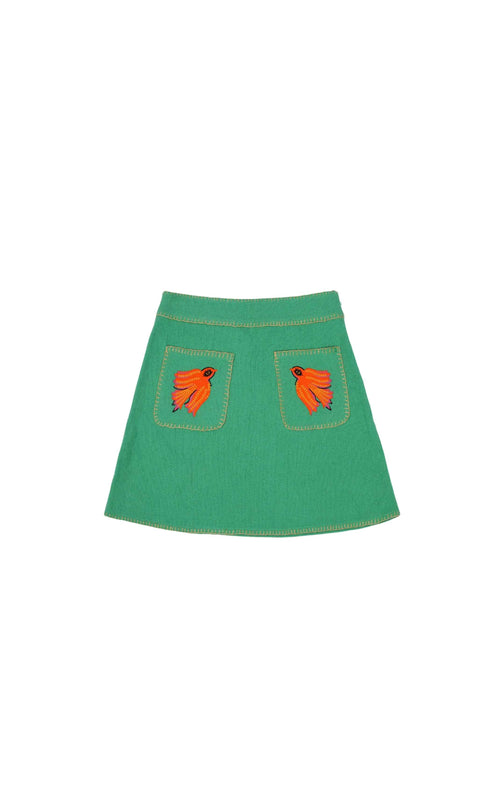Green skirt with orange leaf designs on a white background