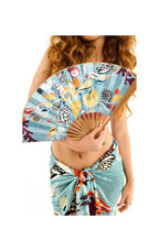 Woman holding a colorful hand fan with a tropical design on a white background