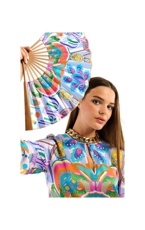 Woman holding a colorful hand fan with matching outfit on a white background