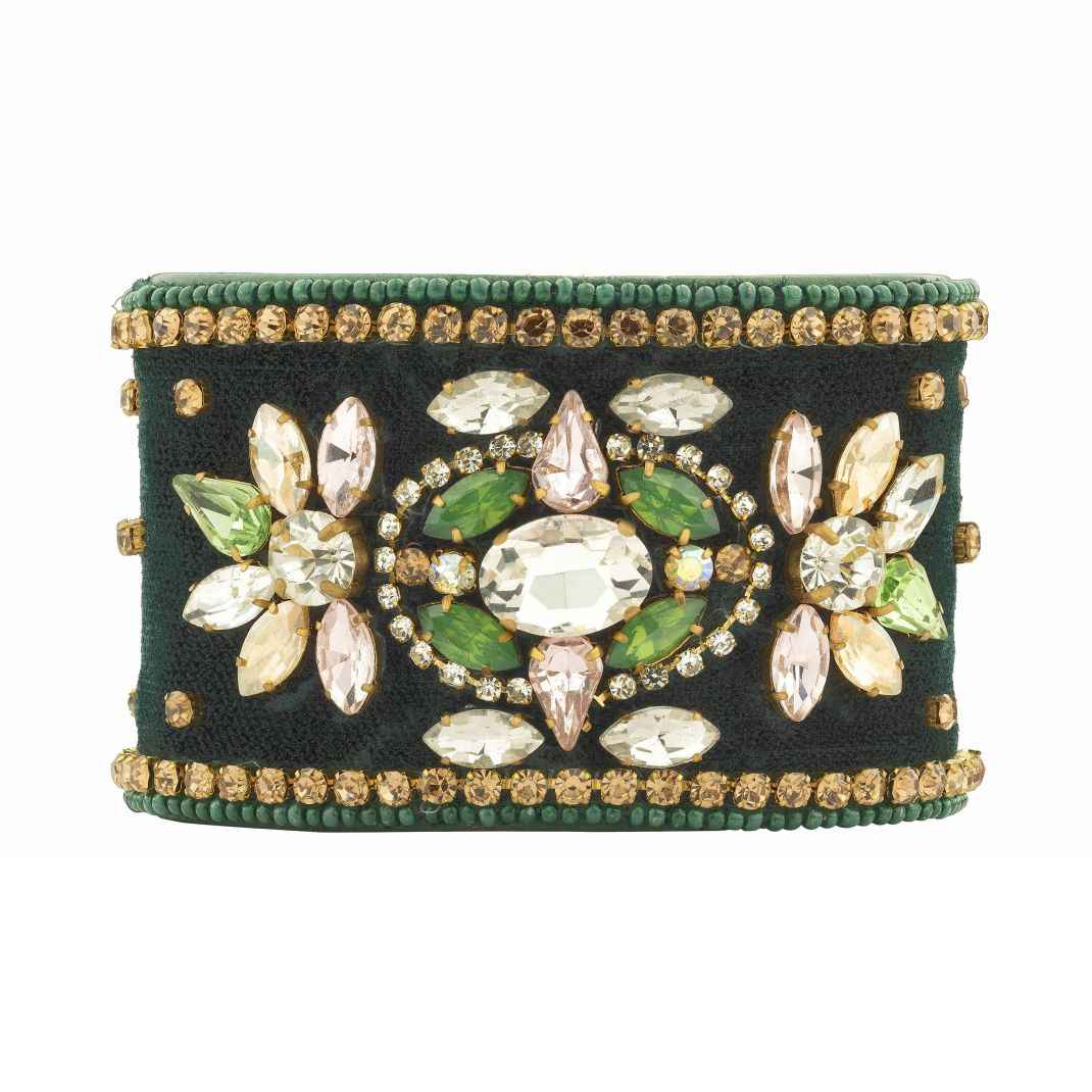 Decorative bracelet with green and gold stones on a white background