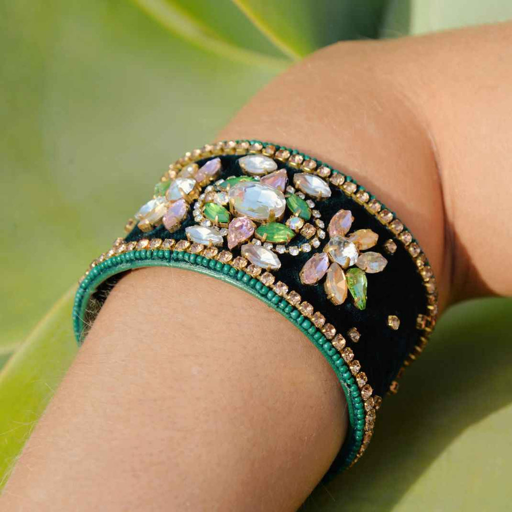 Decorative bracelet with gemstones on a wrist against a natural background