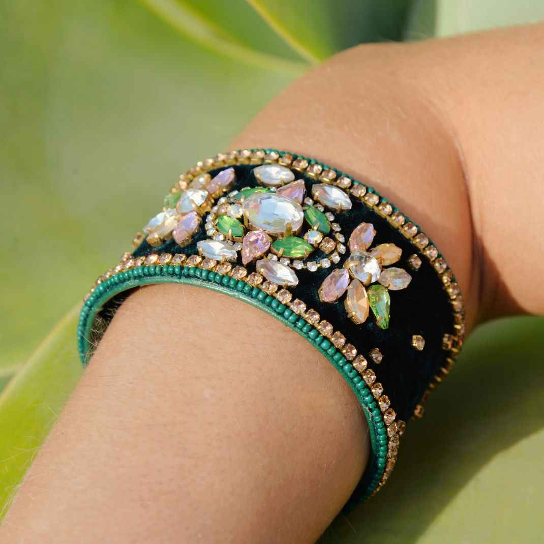 Decorative bracelet with gemstones on a wrist against a natural background