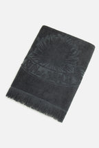 Dark gray towel with fringes on a white background