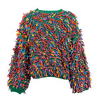 A vibrant, multicolored chunky knit sweater with long, curly yarn-like sleeves and a green ribbed crew neck, cuffs, and hem, shown against a plain white background.