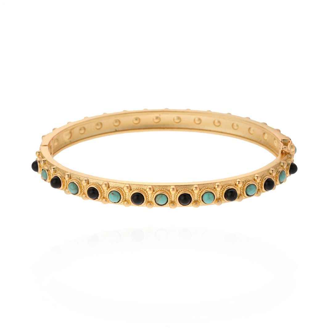 Gold bracelet with green and black stones on a white background