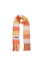 A striped knit scarf with orange, yellow, and off-white horizontal bands, featuring fringe ends and a white patch with the brand name 'WILD' printed in black.