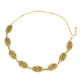 A gold-tone metal statement belt made of ornate filigree oval links joined by chain, with a lobster clasp and extender chain, coiled on a white background