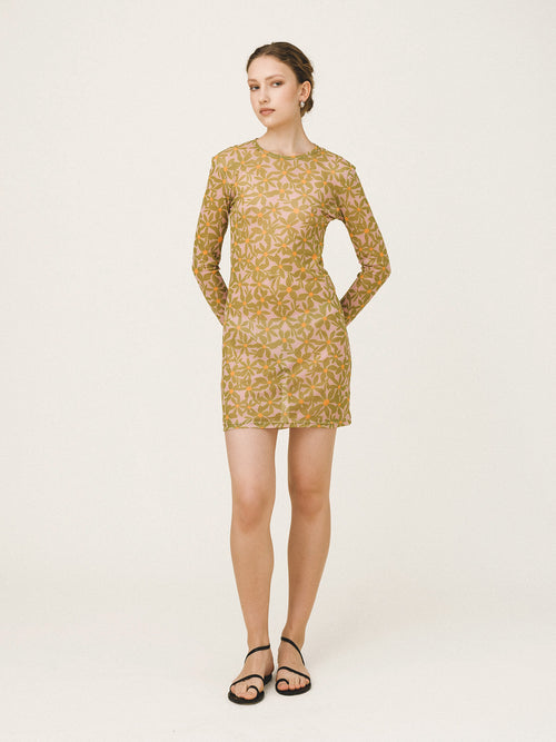 Woman wearing a patterned dress on a plain background