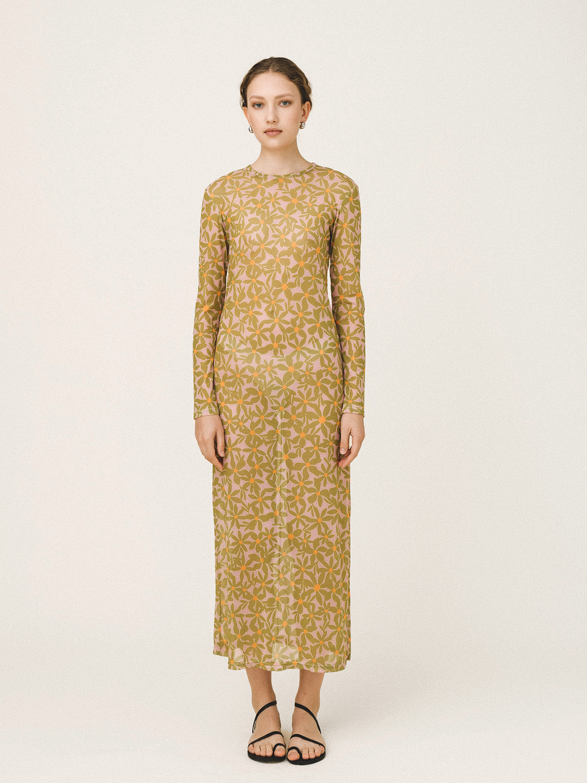 Woman wearing a yellow floral dress on a white background