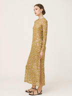 Woman wearing a long-sleeve, patterned dress on a white background