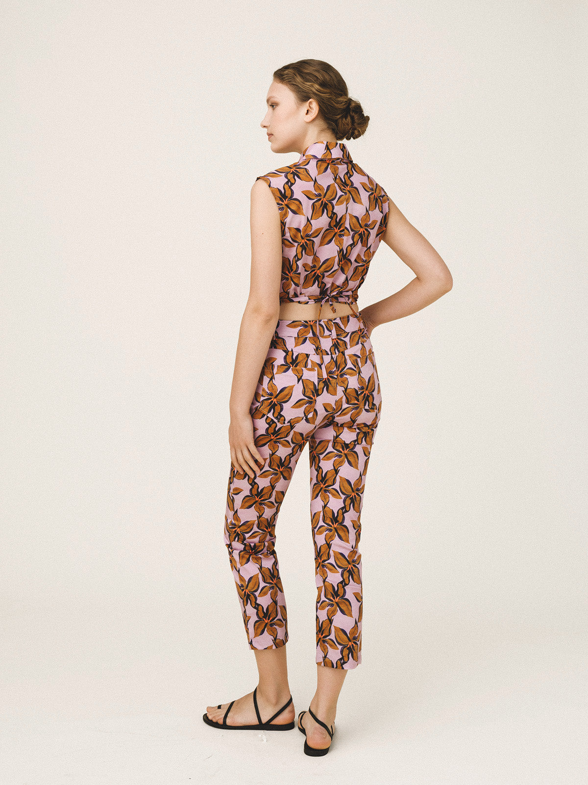 Woman wearing a patterned jumpsuit on a white background