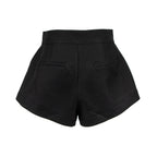 Black high-waisted shorts with a structured silhouette, wide legs, and two welt pockets on the back, shown against a plain white background.