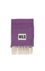 A purple knit scarf with cream-colored fringe and a white rectangular patch featuring the black text 'WILD'.