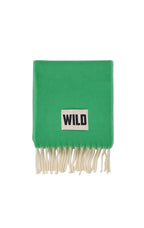 A bright green knit scarf with cream-colored fringe and a white rectangular patch featuring the black text 'WILD'.