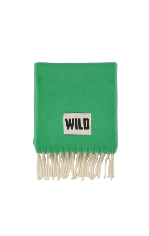 A bright green knit scarf with cream-colored fringe and a white rectangular patch featuring the black text 'WILD'.