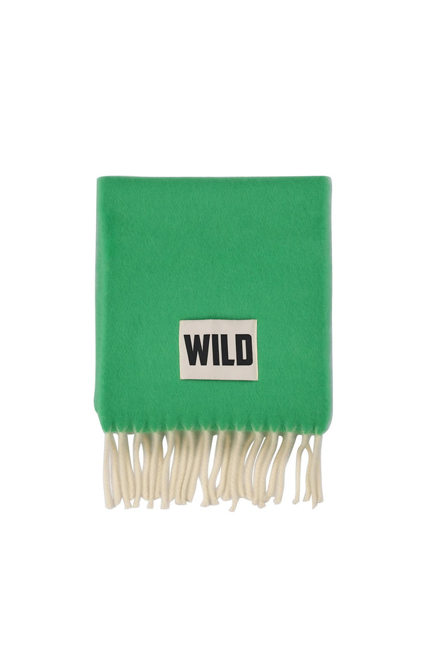 A bright green knit scarf with cream-colored fringe and a white rectangular patch featuring the black text 'WILD'.