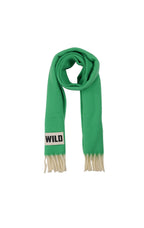 A bright green knit scarf with cream-colored fringed ends and a white rectangular patch near one end featuring the word 'WILD' in black text, shown on a plain white background.