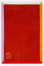 Red fabric with pink and yellow borders and a logo in the corner